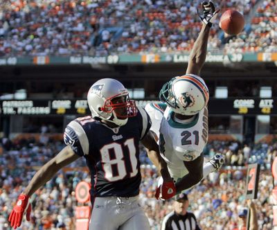 Dolphins’ Andre Goodman bats away a pass intended for the Patriots’ Randy Moss, who caught three touchdown passes.  (Associated Press / The Spokesman-Review)