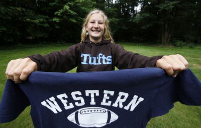 Rebecca Gottlieb holds up a sweatshirt from her new school while wearing one from her old school at her family home on Bainbridge Island, Wash., June 18.  (Associated Press / The Spokesman-Review)