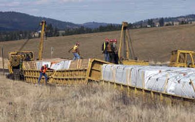 
Crews from Hulcher Professional Services work on standing up one of the derailed Union Pacific cars on the tracks at Highway 27 and Jackson Road near Mica. Nine cars derailed Wednesday afternoon. 
 (Liz Kishimoto / The Spokesman-Review)