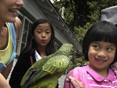 
Rachel Swartzwelder, 6, right, tries to get a kiss from Gorgeous the parrot while her sister, Bethany, 9, watches at the Wishing Star fund-raiser at Granite Point Park on Saturday. Longhorn BBQ catered the event and many local vendors had booths. 
 (Photos by Jed Conklin/ / The Spokesman-Review)