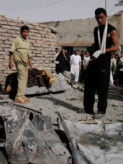 
Iraqis examine a car outside a home after a car-bomb attack in Samarra on Saturday. 
 (Associated Press / The Spokesman-Review)