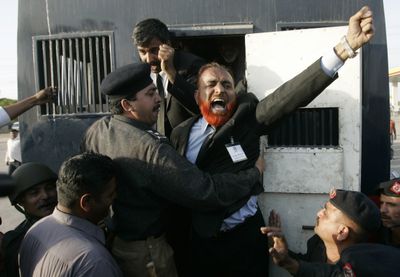 Police officers arrest a protester taking part in an antigovernment march in Karachi, Pakistan, on Thursday.  (Associated Press / The Spokesman-Review)