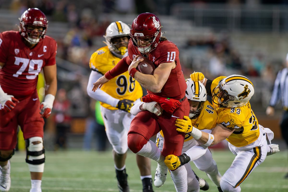 From left, Wyoming’s Jayden Williams, Tyce Westland and Connor Shay bring down WSU quarterback John Mateer.  (Geoff Crimmins/For The Spokesman-Review)