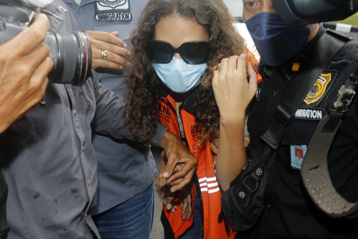 FILE - Heather Mack of Chicago, Ill., center, escorted by immigration officers to Immigration detention center in Jimbaran, Bali, Indonesia on Friday, Oct. 29, 2021. Mack, who served more than seven years in an Indonesian prison for killing her mother at a luxury resort in Bali has been indicted on federal murder conspiracy charges and taken into custody by FBI agents at O