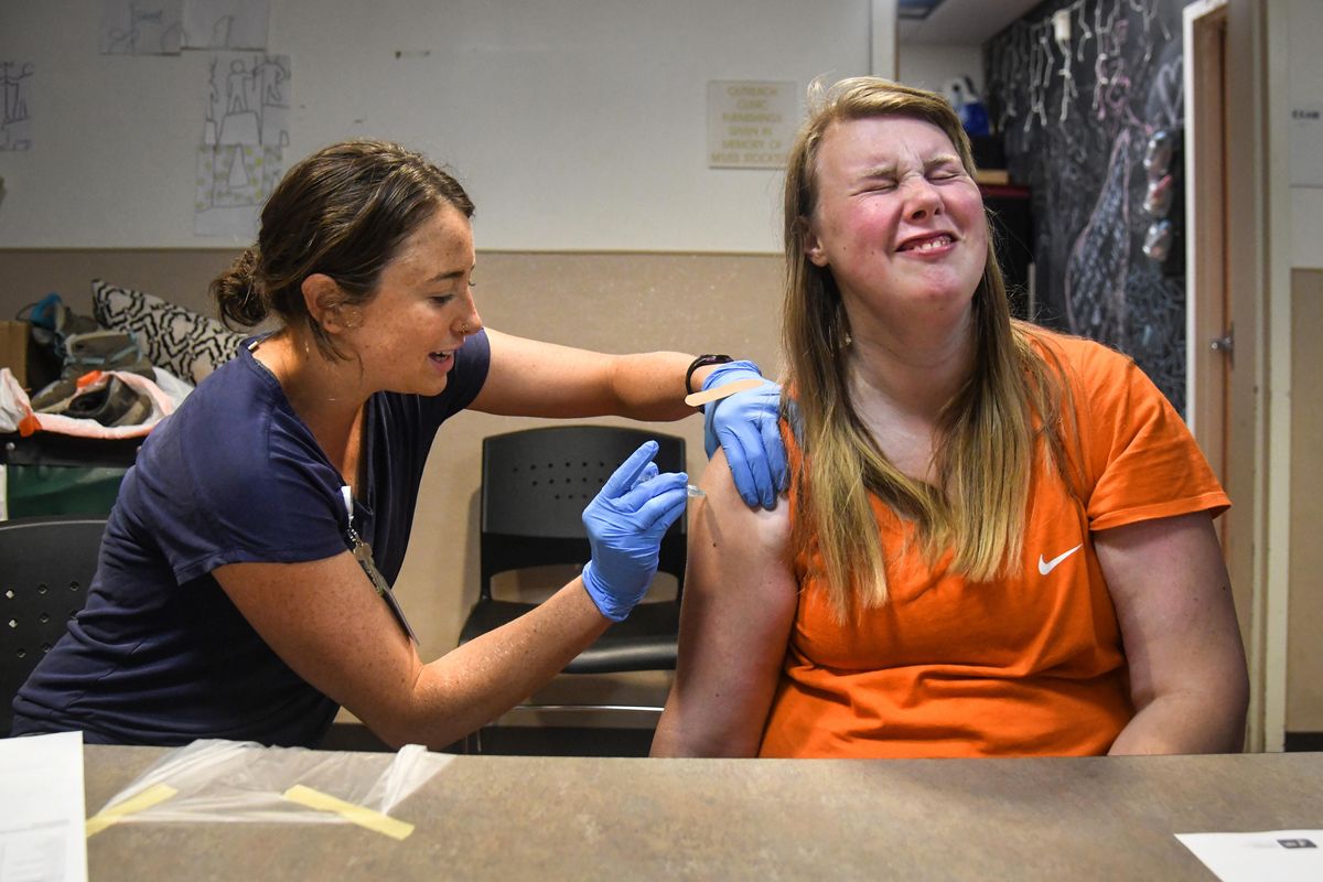 Spokane Regional Health District nurse Kira Lewis, left, administers a hepatitis vaccination to Molly Kircher, 22, Tuesday, Aug. 6, 2019, at the House of Charity in Spokane, Wash. Kircher said the shot was painless. (Dan Pelle / The Spokesman-Review)