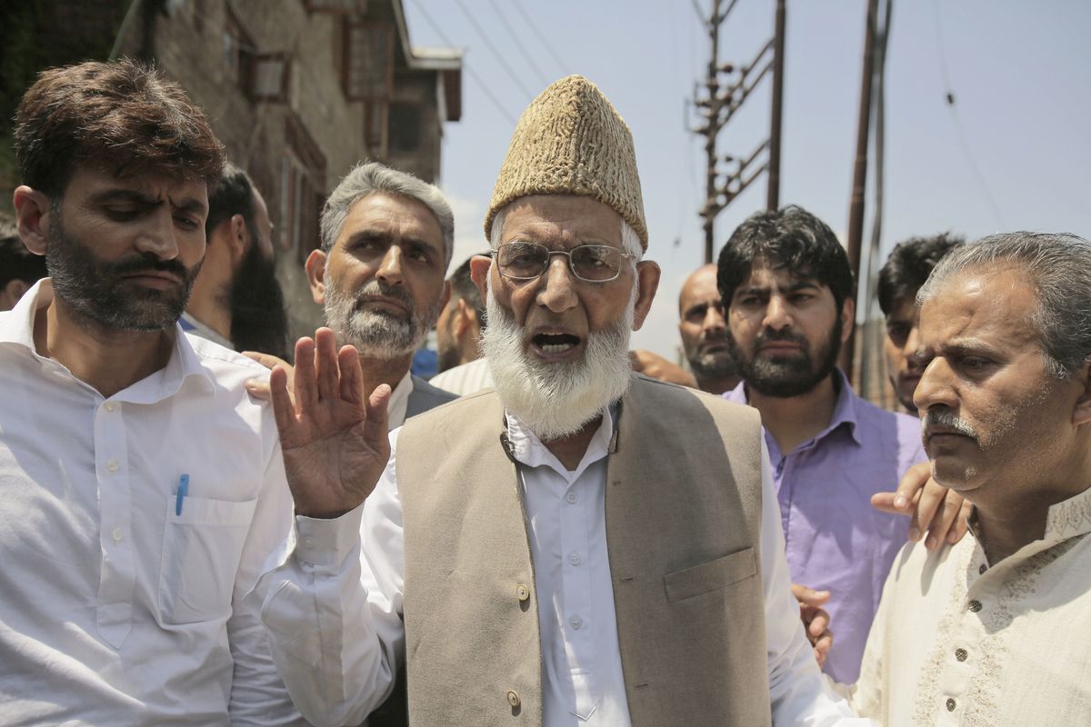 CORRECTS AGE - Syed Ali Shah Geelani speaks to the media as he walks outside his house to participate in a march towards the United Nations Military Observer Group office in Srinagar, Indian controlled Kashmir, Friday, July 29, 2016. Geelani, a top separatist leader and one of the severest critics of Indian rule in the disputed Himalayan region of Kashmir, died late Wednesday, Sept. 1, 2021. He was 91.  (Mukhtar Khan)