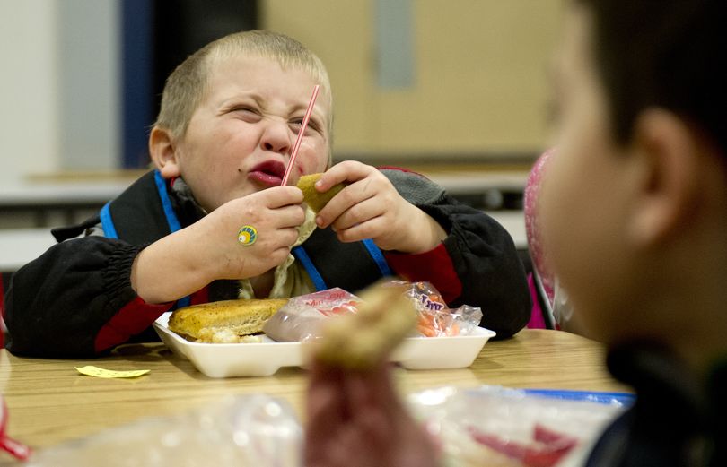 Joshua Bailey, 5, enjoys a kiwi during lunch with fellow kindergartners on Wednesday at Broadway Elementary in Spokane Valley. (Tyler Tjomsland)