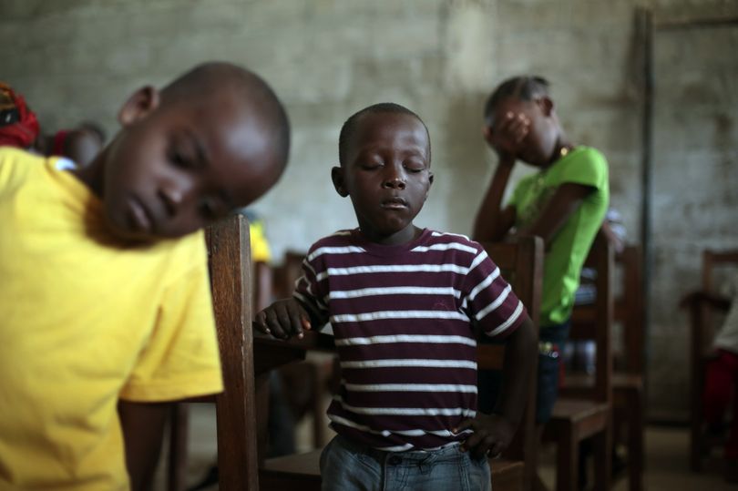 Children pray during a service Sunday at the Bridgeway Baptist Church in the St. Paul Bridge neighborhood of Monrovia, Liberia. (Associated Press)