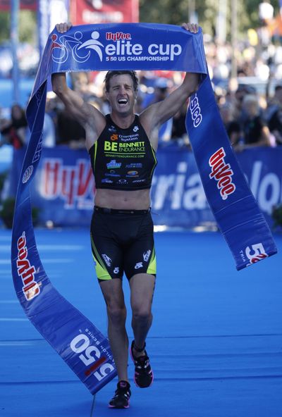 Winner Greg Bennett raises his arms after crossing the finish line. (Associated Press)