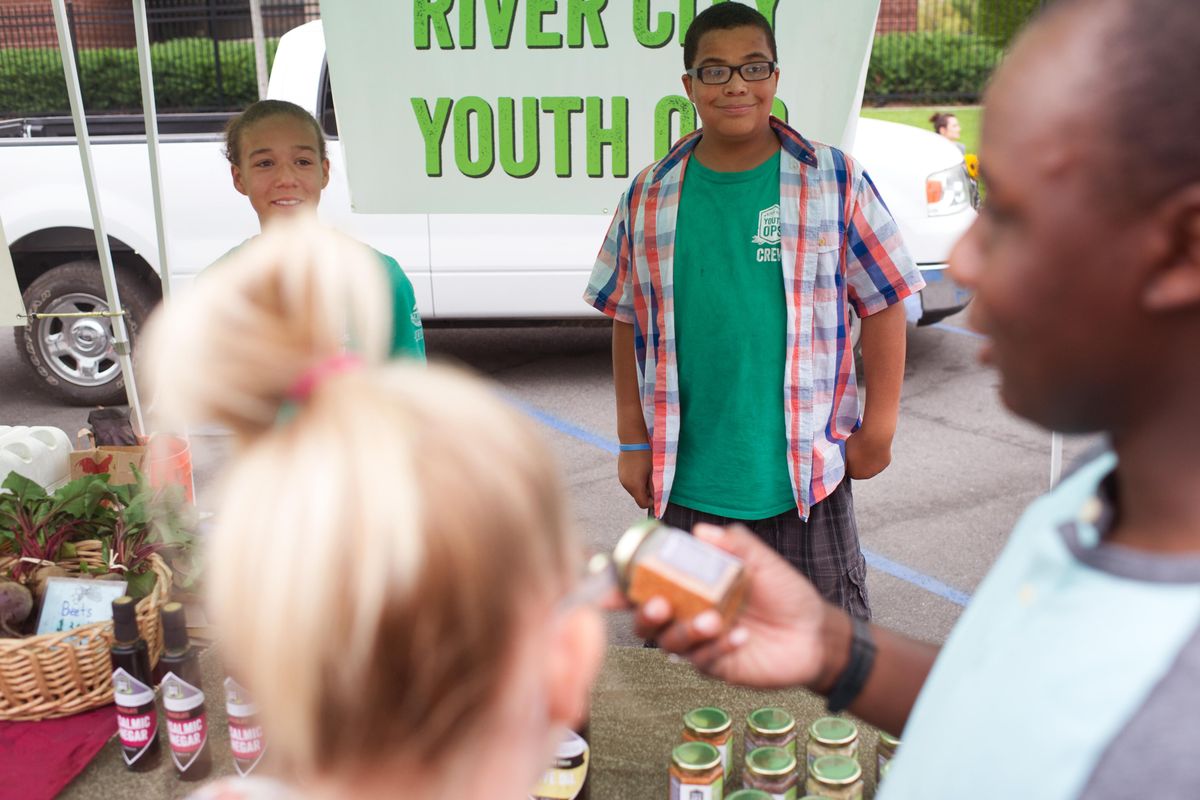 Malik Standley helps sell olive oil and salts with River City Youth Ops on Wednesday, Aug 23, 2017, at the Kendall Yards Wednesday Night Market in Spokane, Wash. (Tyler Tjomsland / The Spokesman-Review)