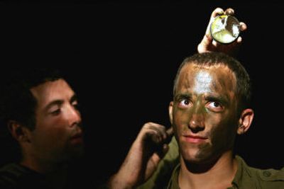 
An Israeli soldier colors the face of another soldier as they prepare to advance toward the northern Gaza Strip early today. 
 (Associated Press / The Spokesman-Review)