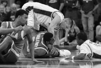 
Washington's Jon Brockman, behind, and Justin Dentmon, right, fight for a loose ball with UCLA. 
 (Associated Press / The Spokesman-Review)