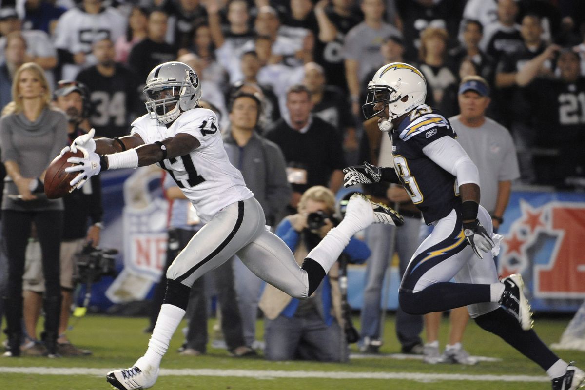 Raiders’ Denarius Moore catches a pass in the second quarter in front of Chargers cornerback Quentin Jammer. (Associated Press)