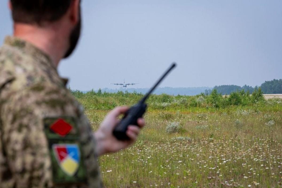 A Canadian Armed Forces member assists with the radio communications during the landing of a CC-130J Hercules transport aircraft during the evacuation of residents due to wildfires in Fort Hope, Ontario, Canada July 19, 2026.   (Master Corporal Natasha Punt/Canadian Armed Forces)