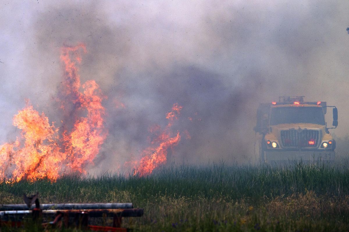 In this Wednesday, June 17, 2015, file photo, the Fish Lake Fire flares up along South Scribner Road and is quickly dealt with by a Spokane County Fire District 3 brush rig. (Colin Mulvany / The Spokesman-Review)