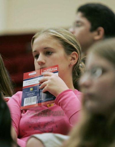 
Lucy Yarosh, 13, of Reston, Va., center, holds a copy of the U.S. Constitution during a debate at the National Archives about the Constitution on Friday. 
 (Associated Press / The Spokesman-Review)