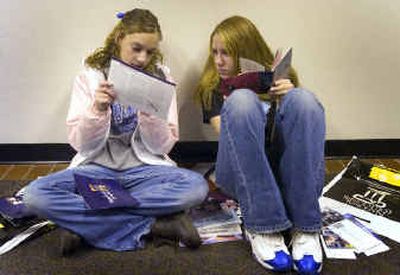 At the annual college fair at the Spokane Convention Center on Monday, Colfax High School's Kim Kopczynski and Heather Rimbey, both 17, check out brochures they collected from colleges they'd like to attend. Nearly 5,000 high school students from the region were able to meet with admissions representatives from postsecondary institutions from around the country. 
 (Colin Mulvany / The Spokesman-Review)