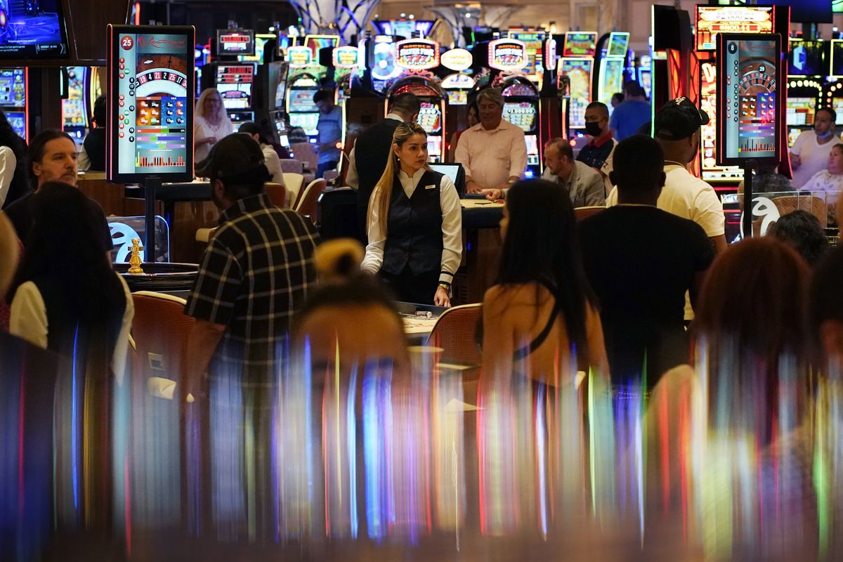 In this June 24, 2021, photo, crowds walk through the casino during the opening night of Resorts World Las Vegas in Las Vegas. Las Vegas fully reopened and lifted restrictions on most businesses June 1, though many casino-resorts had already returned to 100% capacity before that with approval from state regulators. Visitor numbers, while not at their pre-pandemic highs, have grown by double digits four months in a row. But this progress is threatened as Nevada this week saw the highest rate of new COVID-19 cases in the country.  (John Locher)