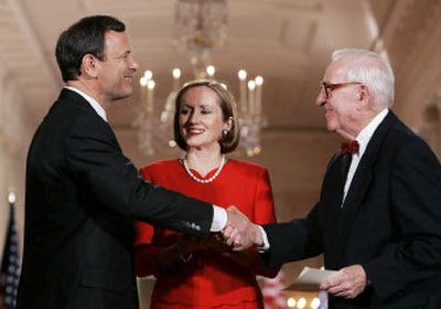 
New Chief Justice of the United States John Roberts is congratulated by Justice John Paul Stevens as Roberts' wife, Jane, looks on at the White House on Thursday. 
 (Associated Press / The Spokesman-Review)