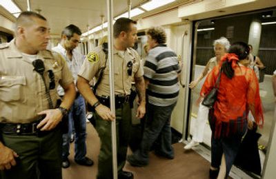 
Los Angeles County sheriff's deputies watch as passengers board the Los Angeles Metro Red Line subway Thursday. Police stepped up security measures on public transit in U.S. cities after the Thursday's bomb attacks in London.
 (Associated Press / The Spokesman-Review)
