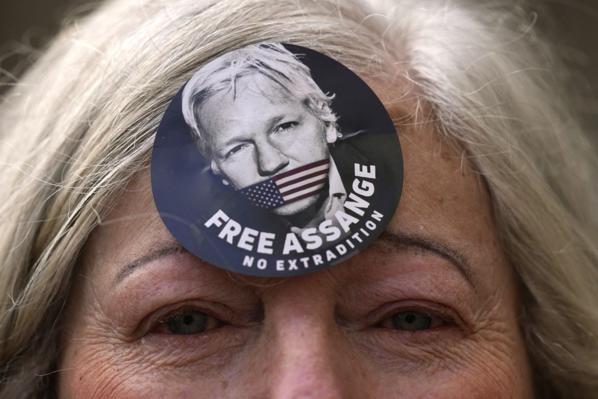 A woman wears a Free Assange badge as supporters of Julian Assange stage a demonstration outside the High Court in London, Wednesday, Oct. 27, 2021. The U.S. government is scheduled to ask Britain