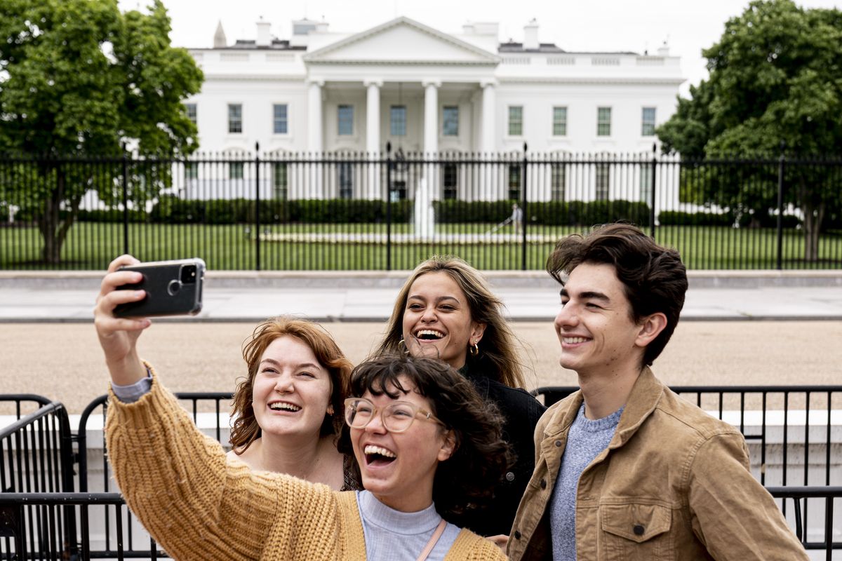 From left, Eliana Lord, Carly Mihovich, Stephanie Justice, and Nick Hansen, visiting from Columbia, S.C., take a photo at Lafayette Park, across the street from the White House, after it reopens in a limited capacity in Washington, Monday, May 10, 2021. Fencing remains in place around the park which will allow the Secret Service to temporarily close the park as they deem necessary.  (Andrew Harnik)