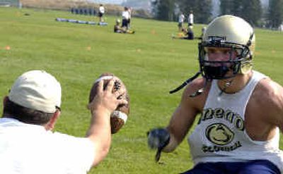 
Mead senior Skyler Jessen sprints toward assistant coach John Covell during drill on the first day of practice. 
 (Kathryn Stevens / The Spokesman-Review)