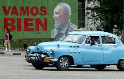 
A taxi passes a sign with Cuban President Fidel Castro that reads: 