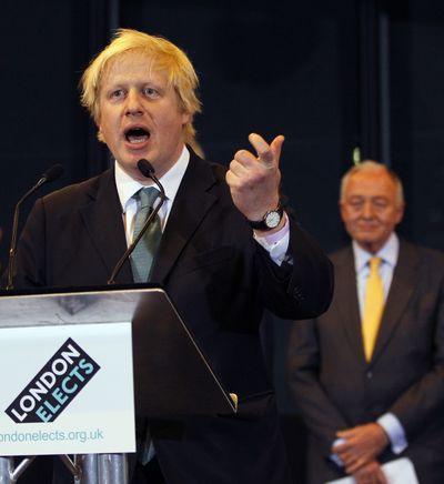 Boris Johnson gives a speech early today after being re-elected as the mayor of London. Johnson beat his Labour rival Ken Livingstone, seen in the background. (Associated Press)