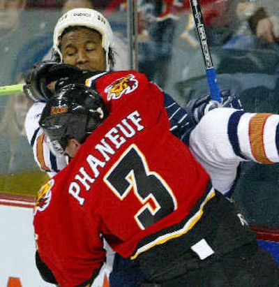
Edmonton's Georges Laraque is knocked into the boards by Calgary's Dion Phaneuf during an October game.
 (Associated Press / The Spokesman-Review)