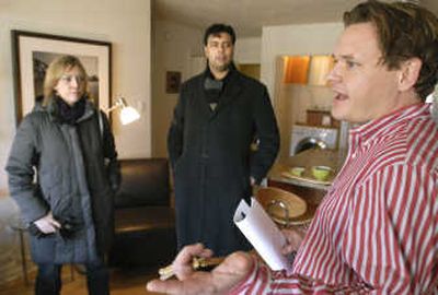 
Realtor Curt Ratcliff of @ Properties, right, talks with potential buyers Italo Subbarao and his wife, Alexandra, as they tour a model condo in Chicago.  Associated Press
 (Associated Press / The Spokesman-Review)