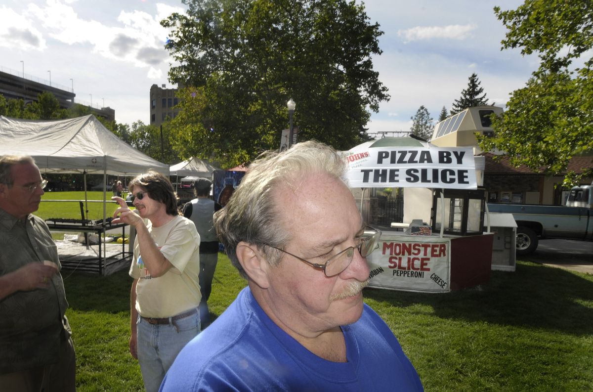 Val Workman, front, the self-proclaimed “Mayor of Pig Out” and founder Bill Burke, rear left, work on last-minute details Tuesday.  (CHRISTOPHER ANDERSON / The Spokesman-Review)