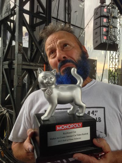 Spokane’s Charlie Schmidt – sporting a newly blued beard – holds the trophy he received at the Minnesota State Fair, where his famous Keyboard Cat was inducted into the Internet Cat Hall of Fame.