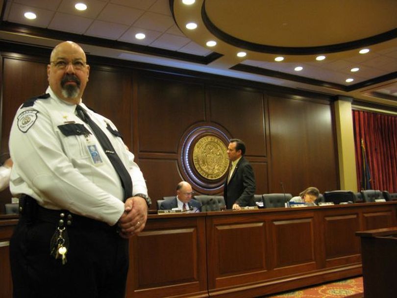 Capitol security guards, including Charlie Harris, left, move in front of Senate State Affairs Committee members after they approved the pre-abortion ultrasound bill on a party-line vote, prompting angry shouts from some in the crowd in the Capitol Auditorium on Wednesday. (Betsy Russell)