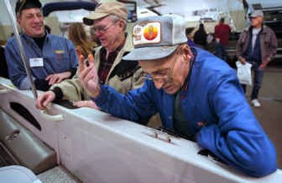
Leroy Slinkard, right, and Bob Durrant, center, share fishing stories with salesman Bob Ploof. 
 (Holly Pickett / The Spokesman-Review)