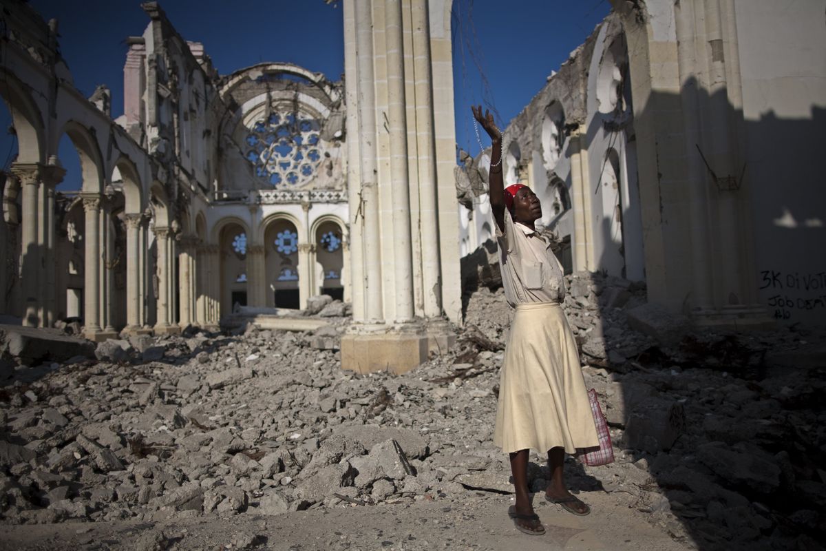 Marie La Jesula Joseph prays Sunday in the rubble of the Notre Dame Cathedral in Port-au-Prince, Haiti, which was damaged in last year