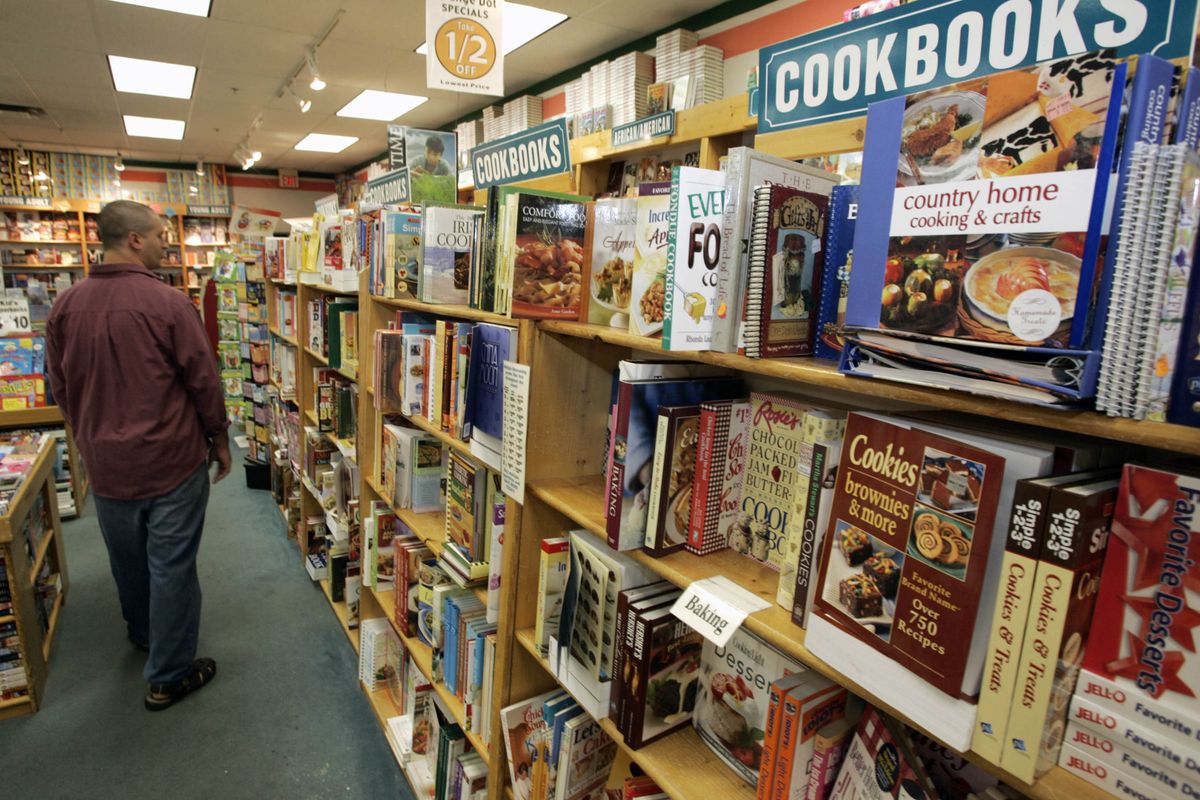 A man walks down the cookbook aisle at a bookstore in a Grove City, Pa., mall. More people are cooking meals at home rather than eating out, a trend that has helped boost sales of cookbooks and inexpensive cookware, according to recent surveys.  (Associated Press / The Spokesman-Review)