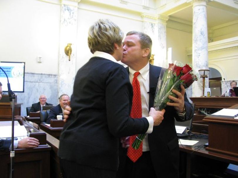 Idaho Attorney General Lawrence Wasden kisses wife Tracey after presenting her with a surprise bouquet of roses at the start of his budget presentation to lawmakers on Tuesday, Valentine's Day. (Betsy Russell)