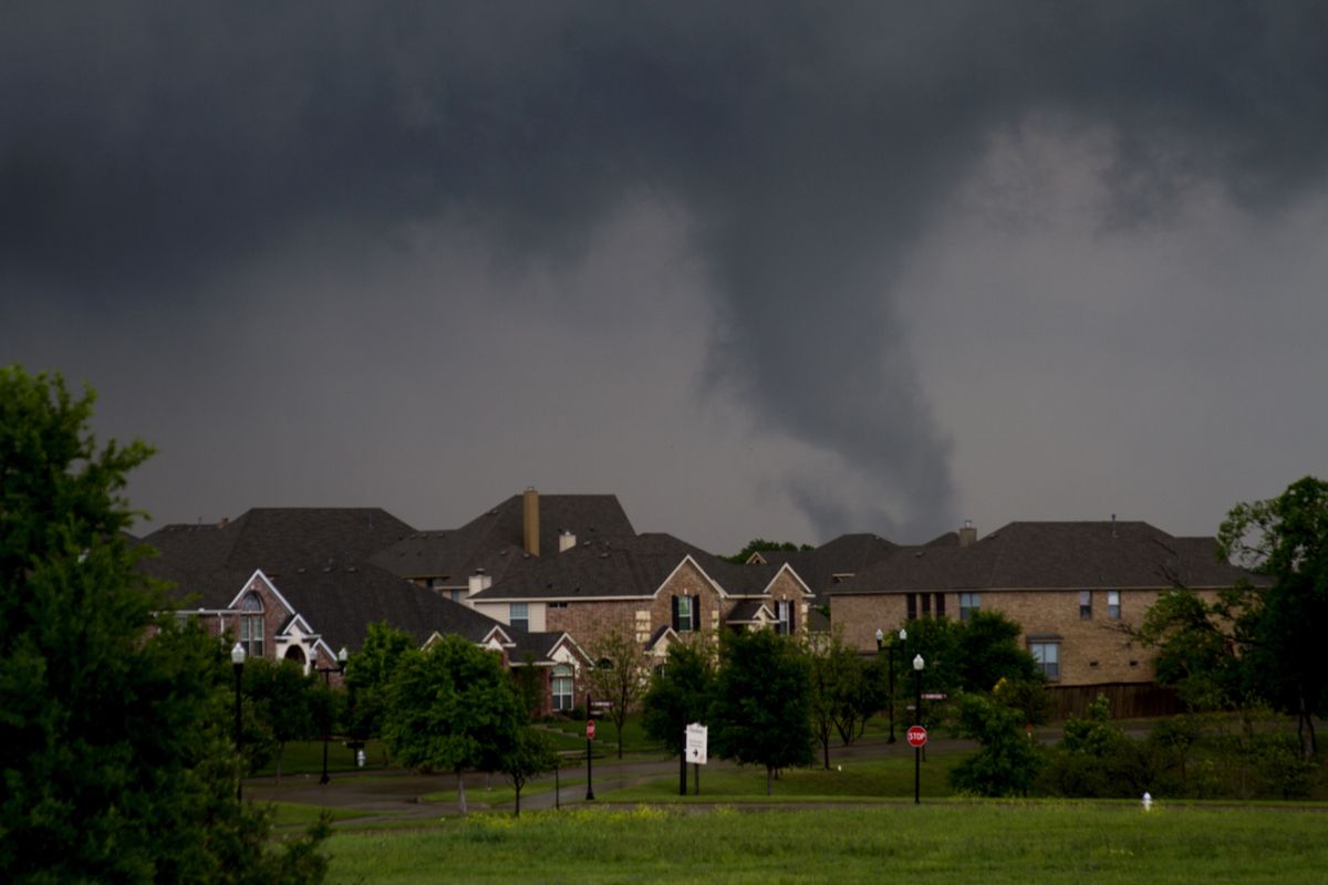 A funnel cloud begins to form in southern Dallas county before a tornado touched down in Lancaster, Texas, on Tuesday.