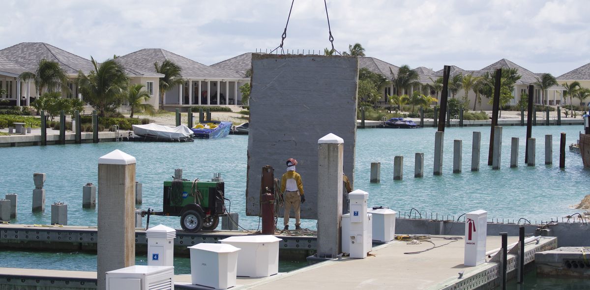 A construction worker stands on the expanded dock for Resorts World Bimini resort, which Malaysia-based Genting Group is spending at least $300 million to develop. (Associated Press)