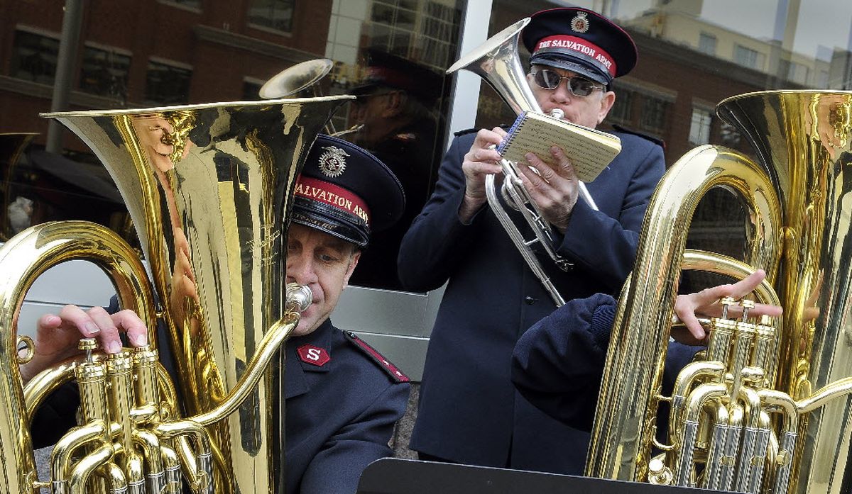 Salvation Army Capt. Kyle Smith (left), retired Major Tom Peterson (center) and Mark Morrison (right) perform April 2, 2010, with the Spokane Citadel Brass Band on the corner of Riverside Avenue and Howard Street in downtown Spokane. They gathered on the Salvation Army