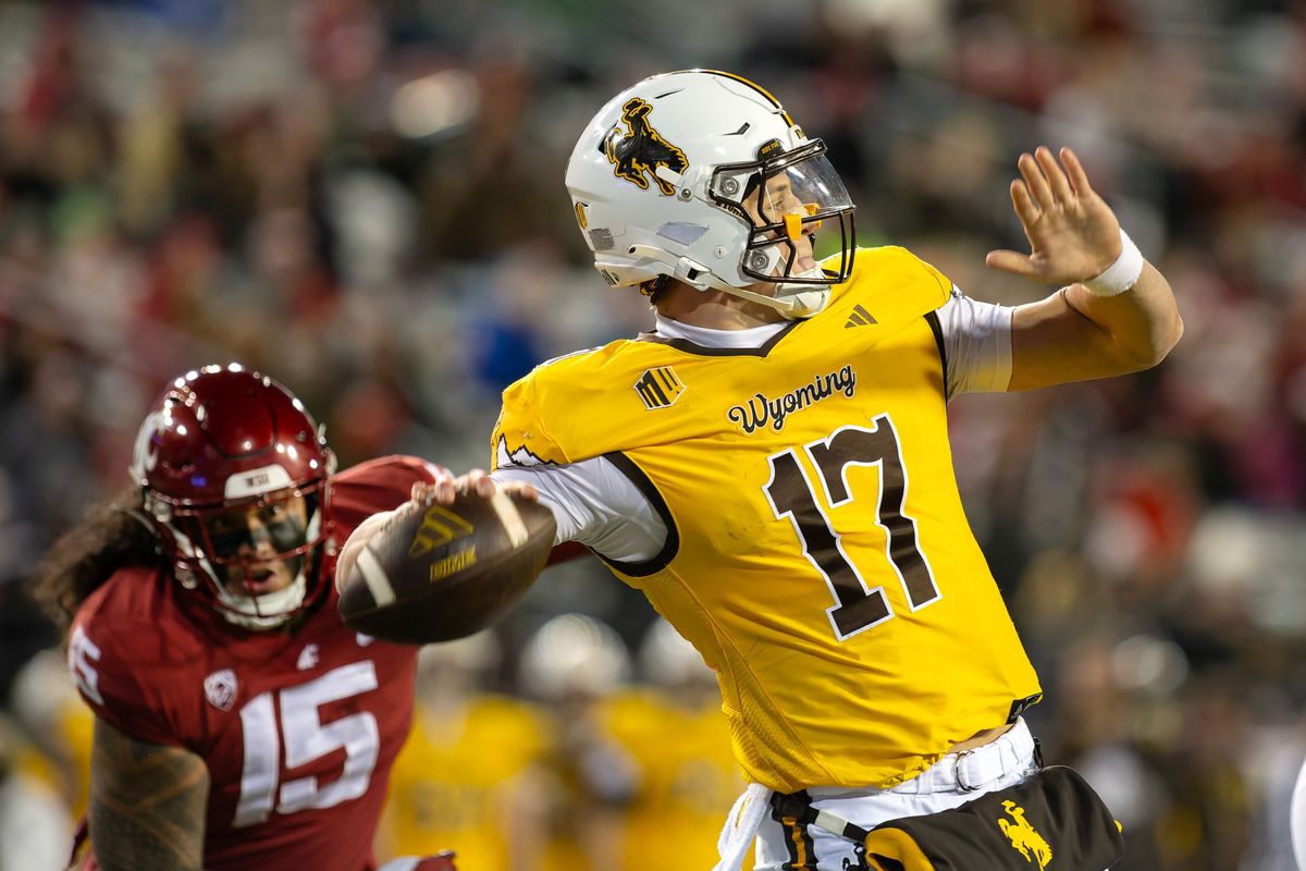 Wyoming quarterback Evan Svoboda passes under pressure from Washington State edge Nusi Malani during Saturday’s game at Gesa Field in Pullman.  (Geoff Crimmins/For The Spokesman-Review)