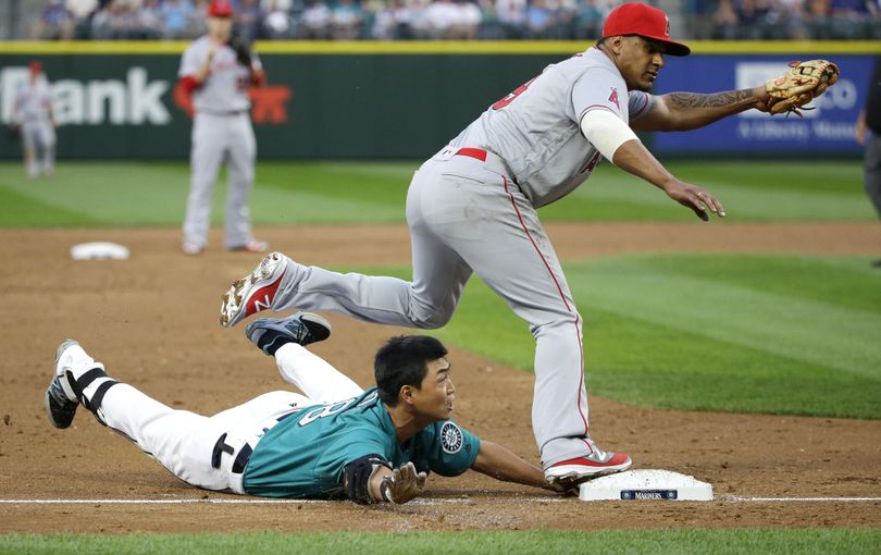 Mariners’ Norichika Aoki is safe at third base with a triple below Los Angeles Angels third baseman Jefry Marte. (Ted S. Warren / Associated Press)