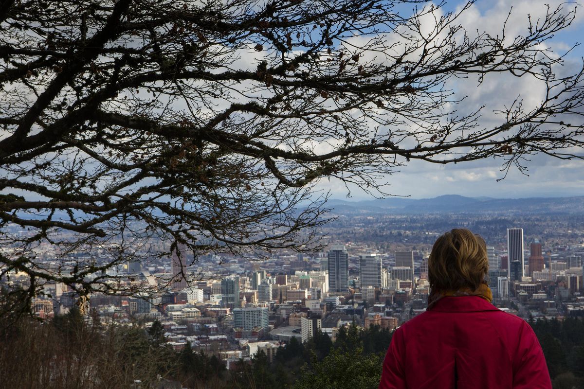 A woman checks out the view of Portland from the Pittock Mansion, looking toward, in foreground, the Pearl District and downtown Portland from Forest Park, a sprawling trail network that makes it possible to go hiking without straying too far from the city’s core. (Ellen M. Banner / Seattle Times)