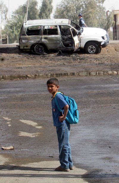 
A boy stands near the site of an attack on the interior minster's convey Wednesday.  The explosion killed two and injured five. The minister was not in the convoy at the time of the blast, police said.
 (Associated Press / The Spokesman-Review)