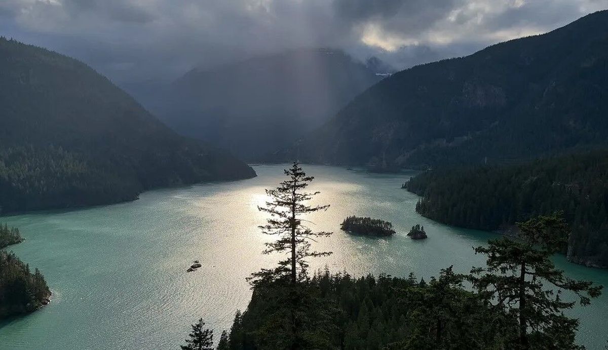 Light filters through the clouds onto Diablo Lake in the North Cascades National Park Complex. Visitors to the Diablo Lake Overlook can peer into the national park but are not, technically, inside its boundaries.  (Erika Schultz/The Seattle Times)