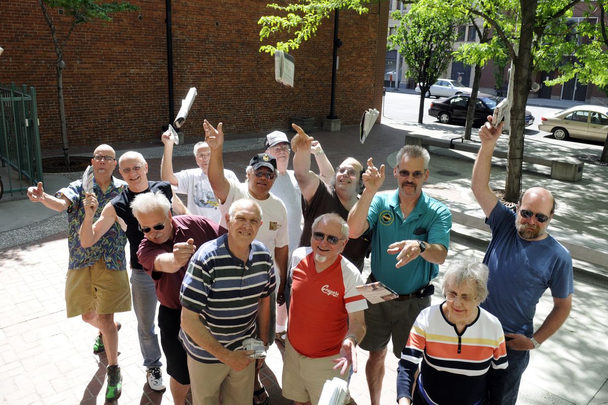 The competitors (from left) Ken Yuhasz, Tim Groh, Al Lundbeck, Archie Oestreicher, Wes Ackerman, J.B. Morrison, Bob Wright, David Thorin, Louis Varns, Mike Carlson, Gladys Johnson and Randy Peterschick toss a paper at the camera in the courtyard of the Spokesman-Review building at the end of the The Slice's paper throwing contest Saturday, May 30, 2009. (Jesse Tinsley / The Spokesman-Review)