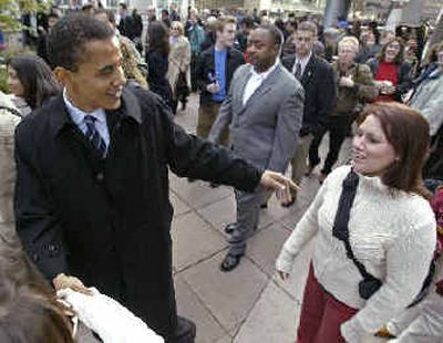 
Democratic Senator-elect Barack Obama, left, greets commuters  on Wednesday in Chicago, after defeating GOP challenger Alan Keyes in Tuesday's election. 
 (Associated Press / The Spokesman-Review)