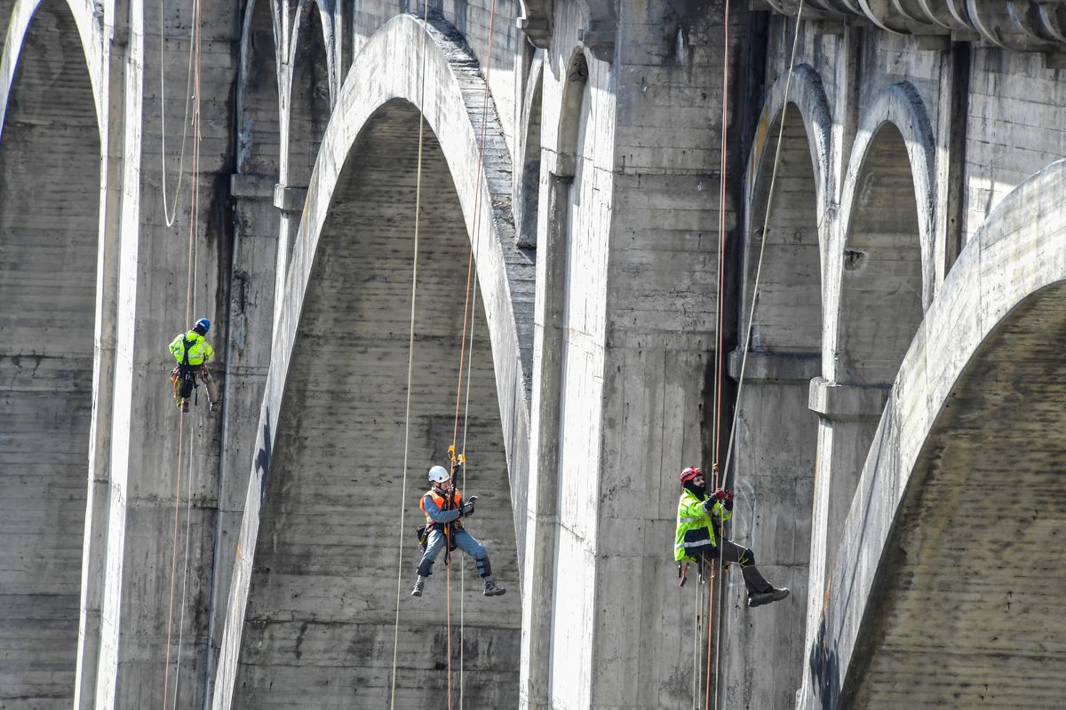 Zach William, of Fickett Structural Solutions, left, Jeremy Miles, HDR Engineering, and Michael Dominguez of Fickett, inspect the south side of 140-foot-tall Latah Creek Bridge for deterioration, Monday, March 9, 2020 in Spokane, Wash. (Dan Pelle / The Spokesman-Review)