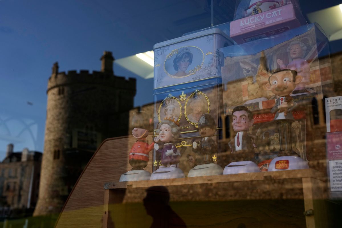 Souvenirs are displayed for sale in the window of a shop with a reflection of Windsor Castle, in Windsor, England, where Prince Andrew residence is nearby in the grounds of Windsor Great Park, Thursday, Jan. 13, 2022. A judge has — for now — refused to dismiss a lawsuit against Britain